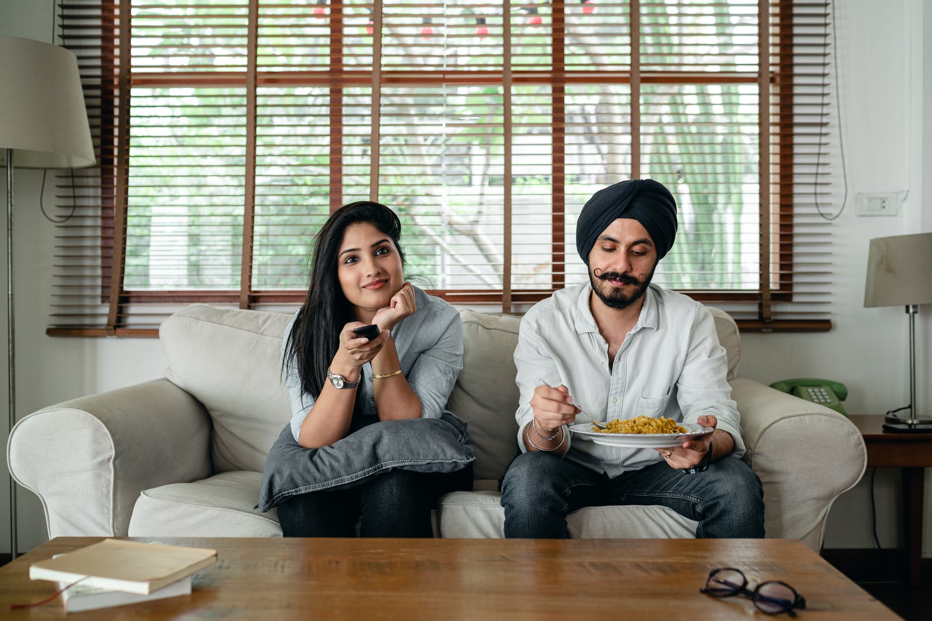 calm ethnic couple watching movie on sofa
