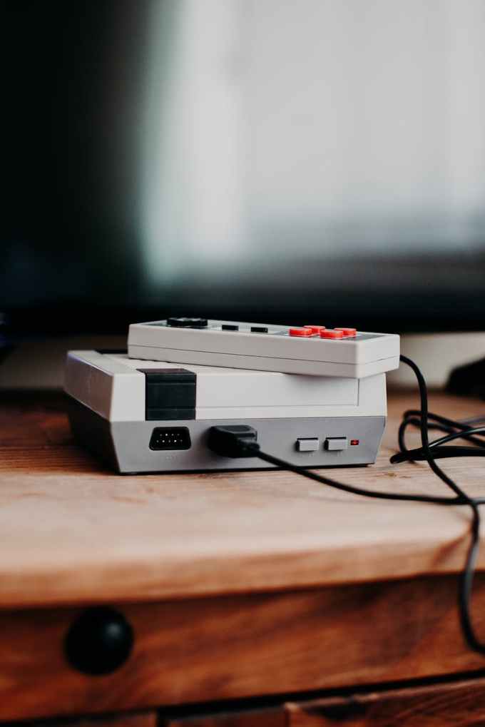 photo of video game console on brown wooden table