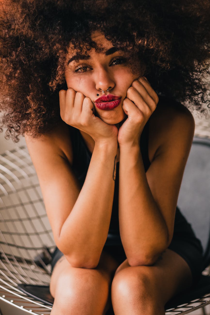 unhappy ethnic woman puffing cheeks with hands